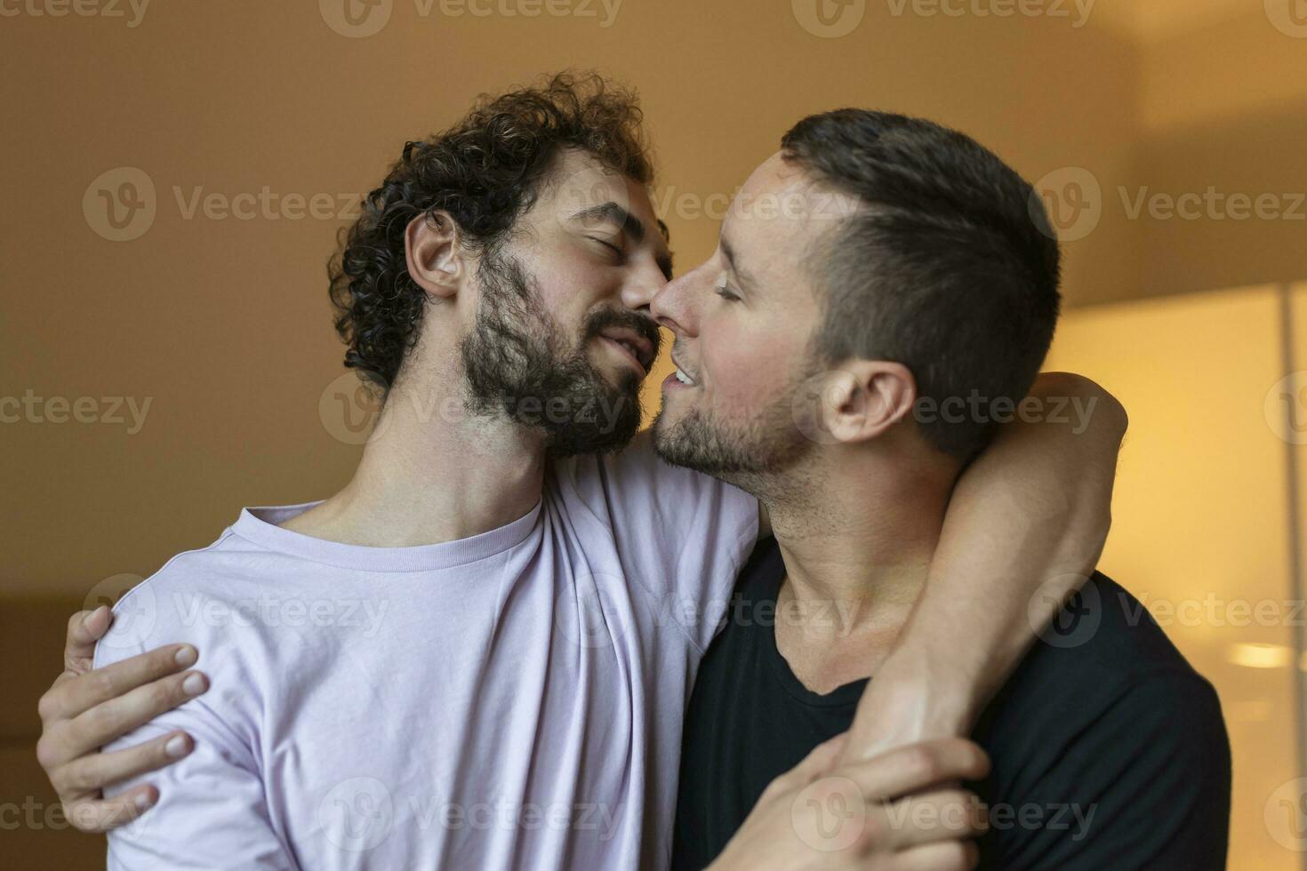 Two young man lgbtq gay couple dating in love hugging enjoying intimate tender sensual moment together kissing with eyes closed photo