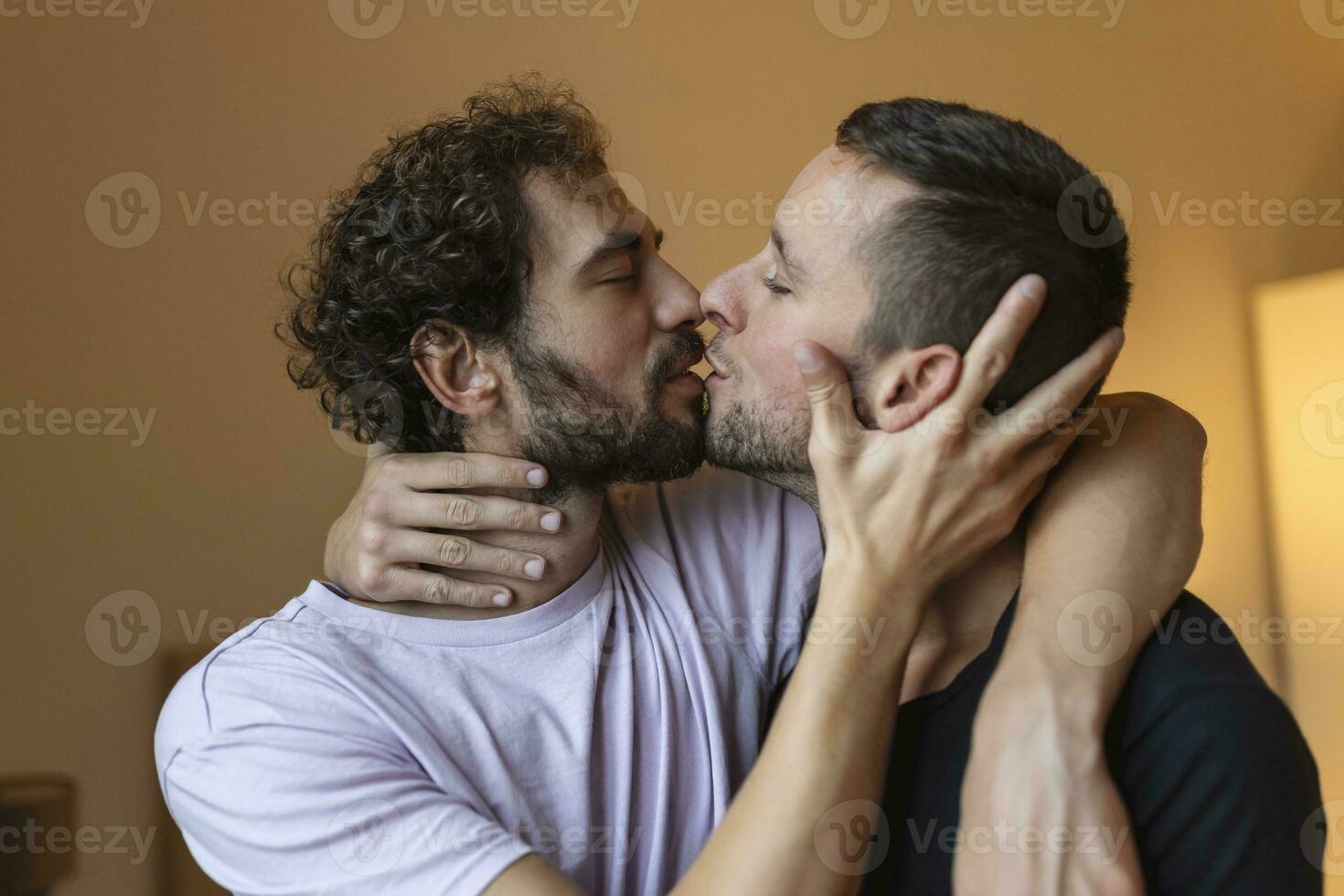 Two young man lgbtq gay couple dating in love hugging enjoying intimate tender sensual moment together kissing with eyes closed photo