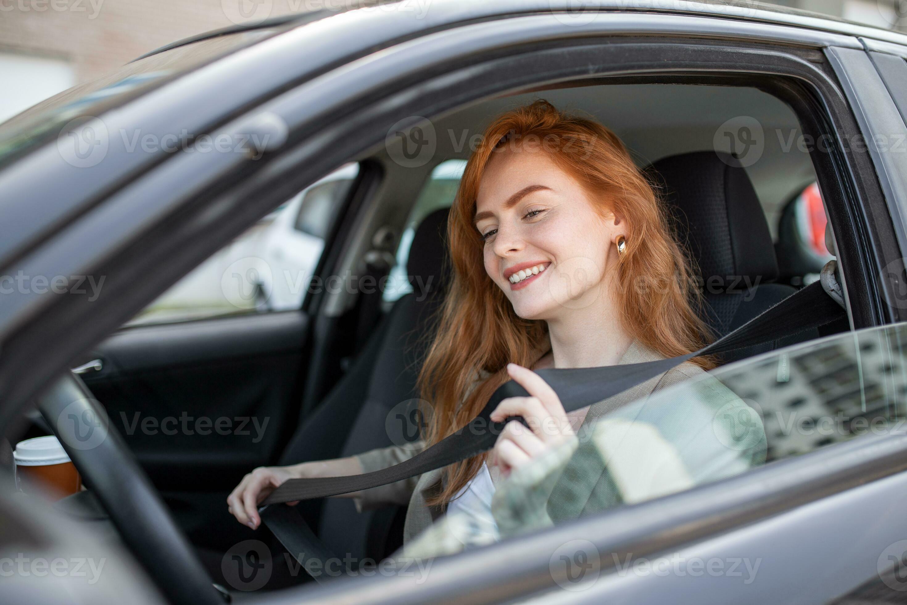 Young woman sitting on car seat and fastening seat belt, car safety