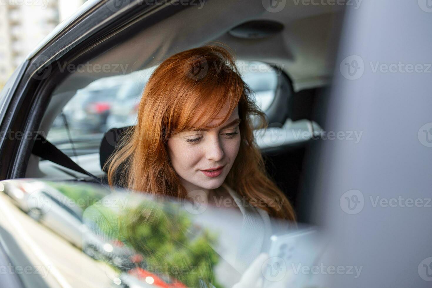Beautiful Businesswoman is Commuting from Office in a Backseat of Her Luxury Car. Entrepreneur Passenger Traveling in a Transfer Taxi in Urban City Street photo