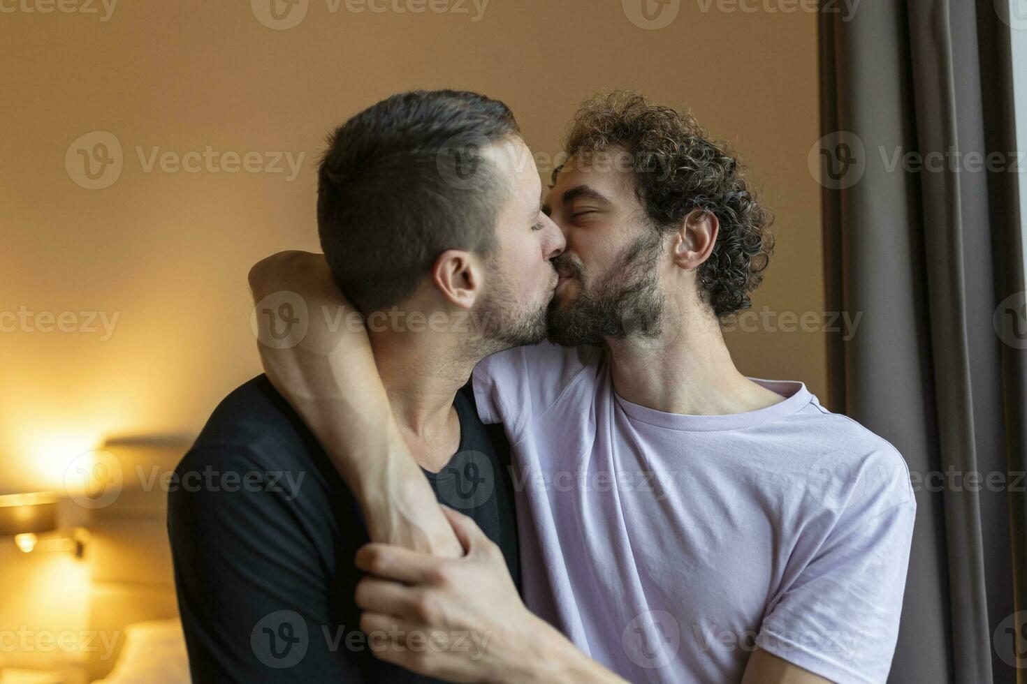 Two young man lgbtq gay couple dating in love hugging enjoying intimate tender sensual moment together kissing with eyes closed photo