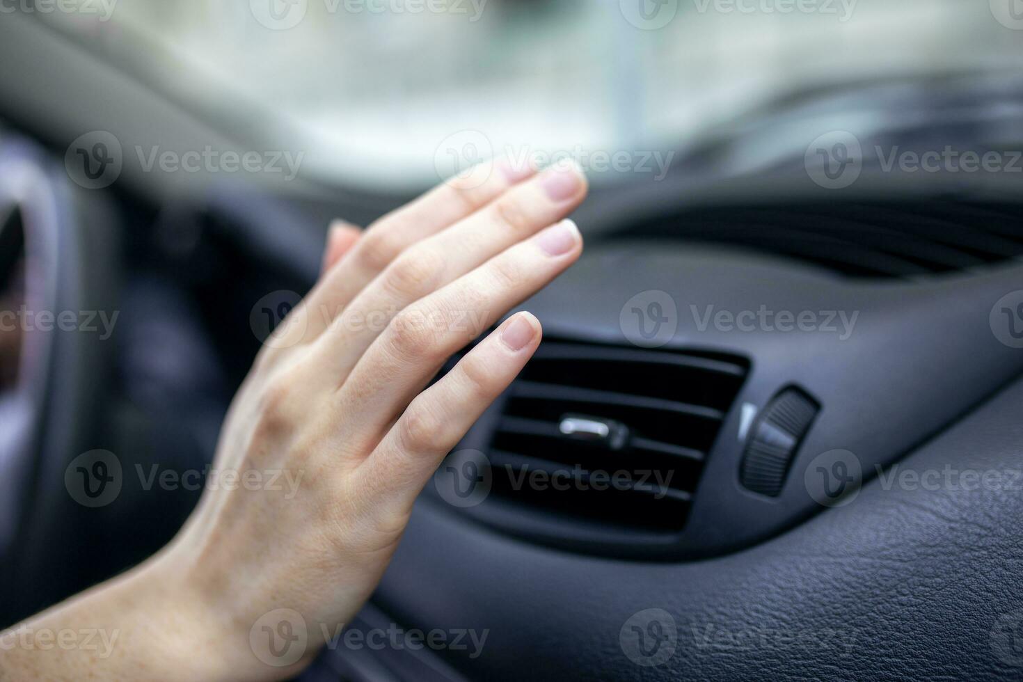 woman adjusting the cooling inside her car, Closeup of hand driver checking adjusting air from conditioning the cooling system with flow of cold air in car. photo