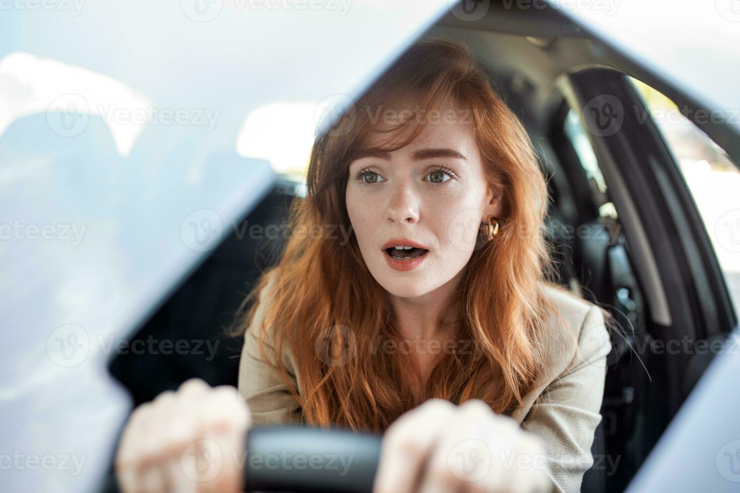 Young terrified woman driving and having a car accident. adult woman driving and looking scared and surprised at the road in front of her. Woman in Car Crash photo