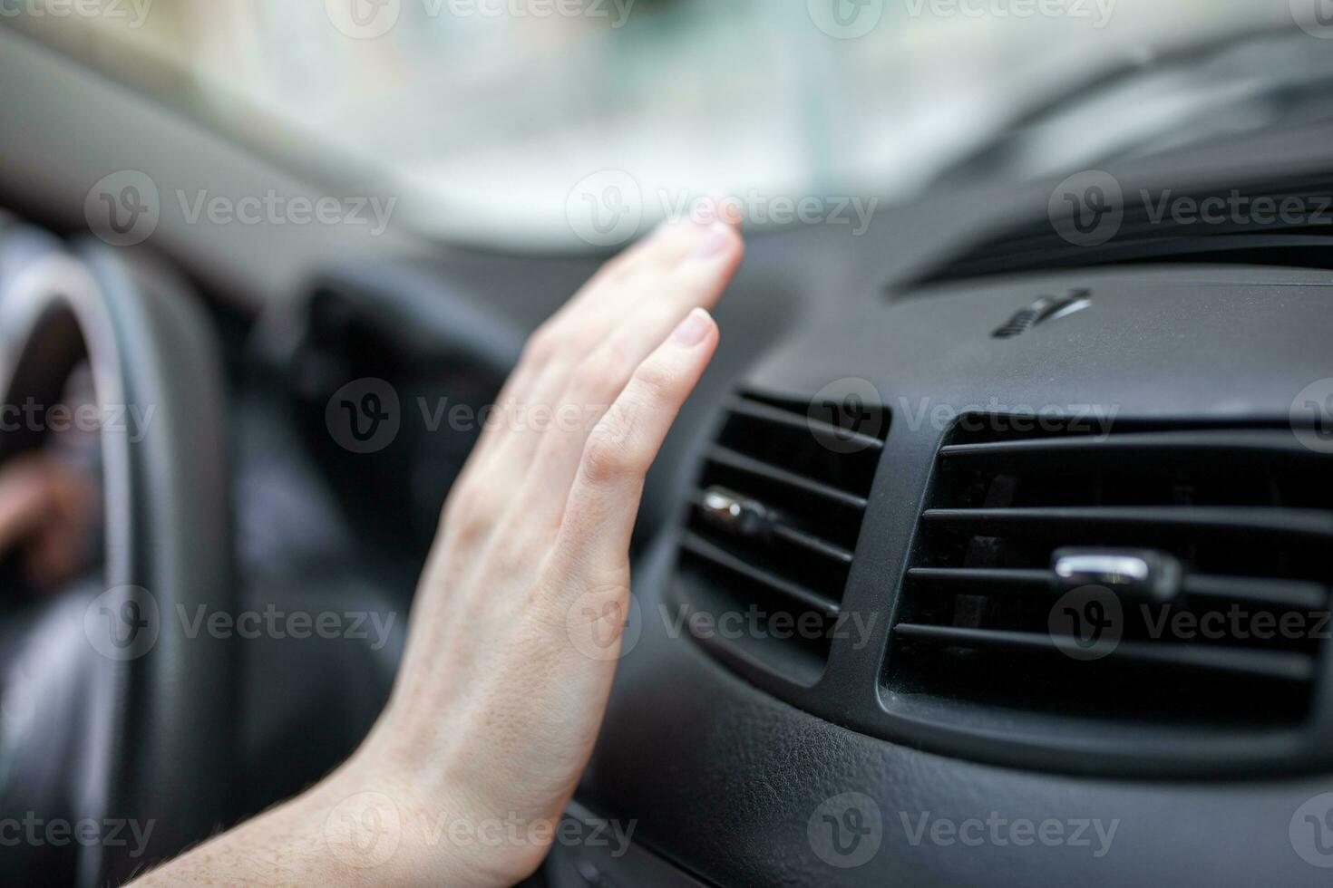 woman adjusting the cooling inside her car, Closeup of hand driver checking adjusting air from conditioning the cooling system with flow of cold air in car. photo