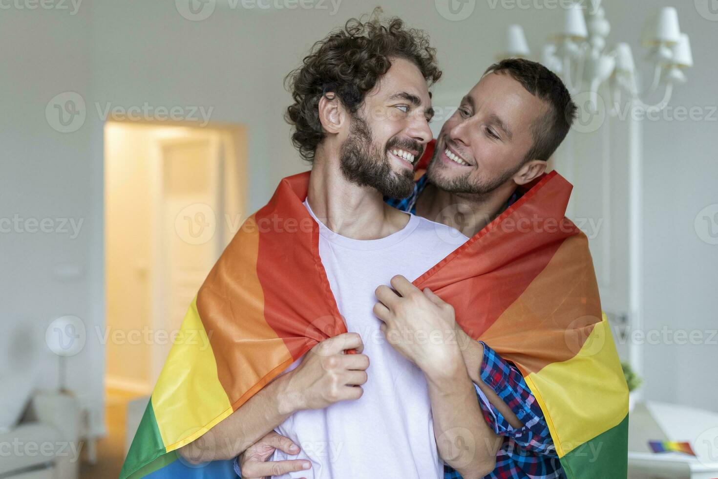 cariñoso masculino gay Pareja adentro. hombre abrazando su novio desde detrás a hogar. gay Pareja celebrando orgullo mes foto