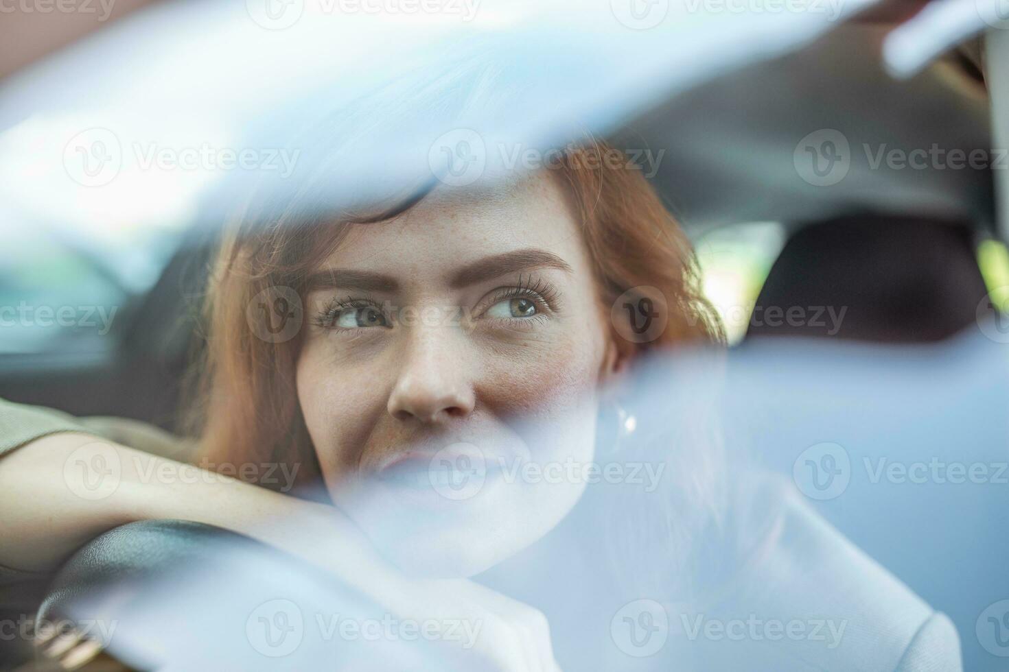 Young Woman Embracing Her New Car. Excited young woman and her new car indoors. Young and cheerful woman enjoying new car hugging steering wheel sitting inside photo