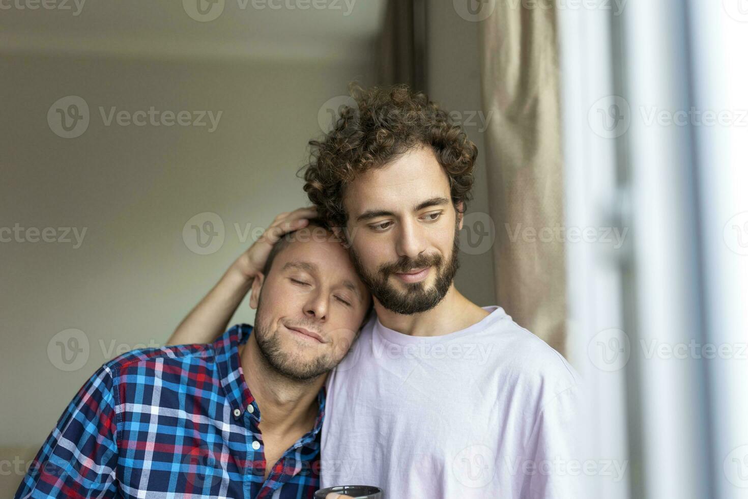 alegre joven gay Pareja sentado juntos. dos cariñoso masculino amantes sonriente alegremente mientras abrazando cada otro. joven gay cupé siendo romántico. foto