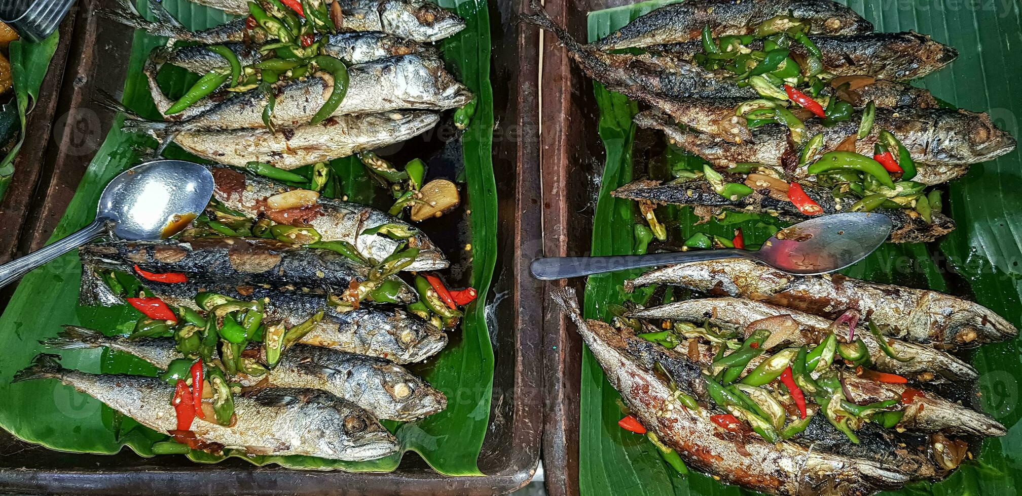 Seafood dish served on the table and plate from above with different kind of dish from fried fish barracuda, snapper, tuna jaws, and also mix of tropical vegetables photo