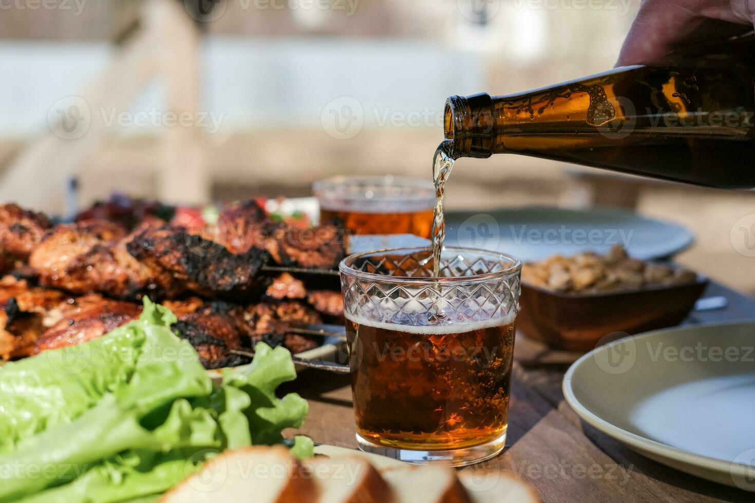 Summer picnic with barbecue, vegetables and beer in the country photo