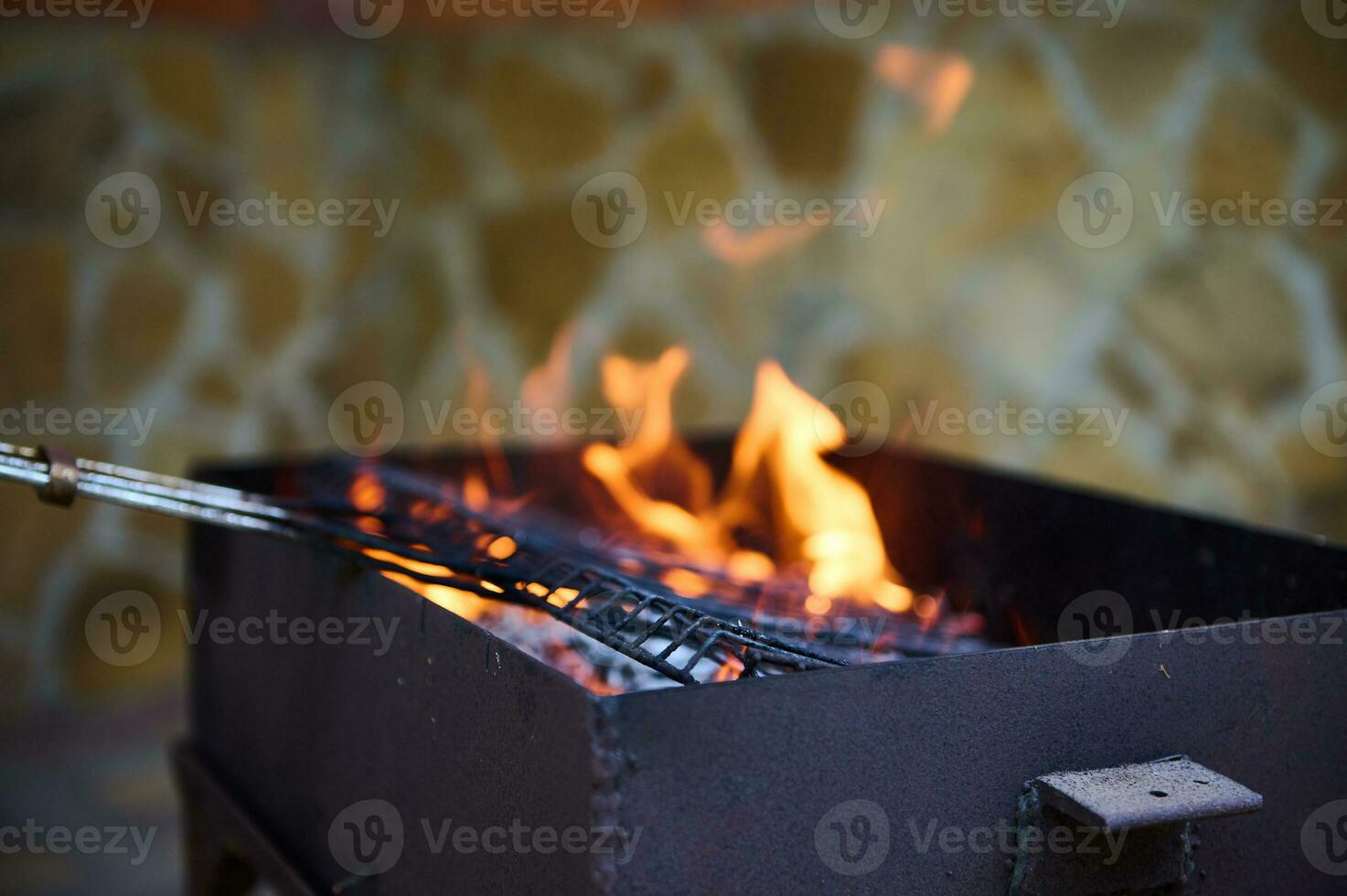 Flaming charcoal grill with open fire, ready for product placement. Summer grilling, barbecue, bbq and party. Close-up photo