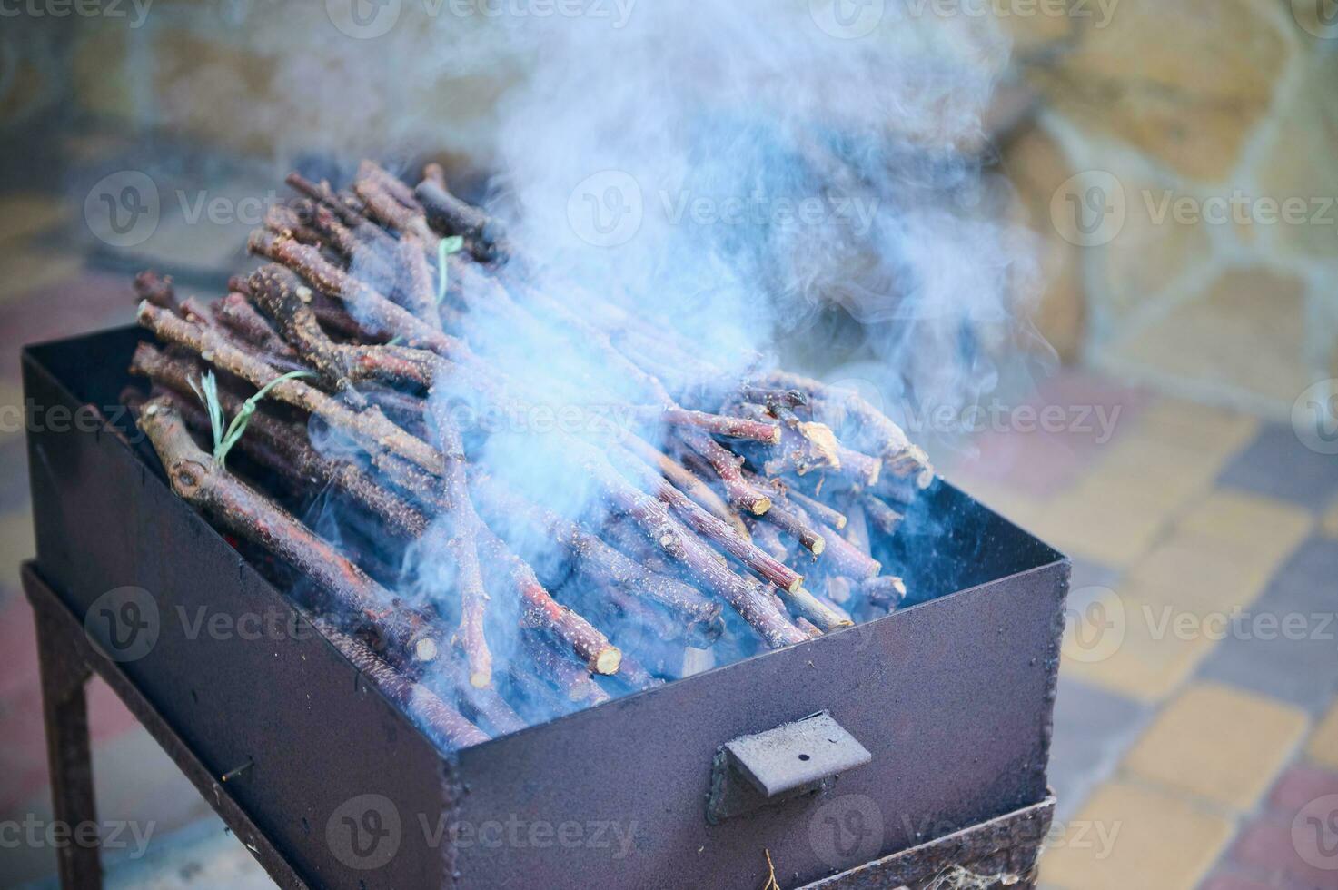 Smoke coming from a hot barbecue fire over a black grill photo