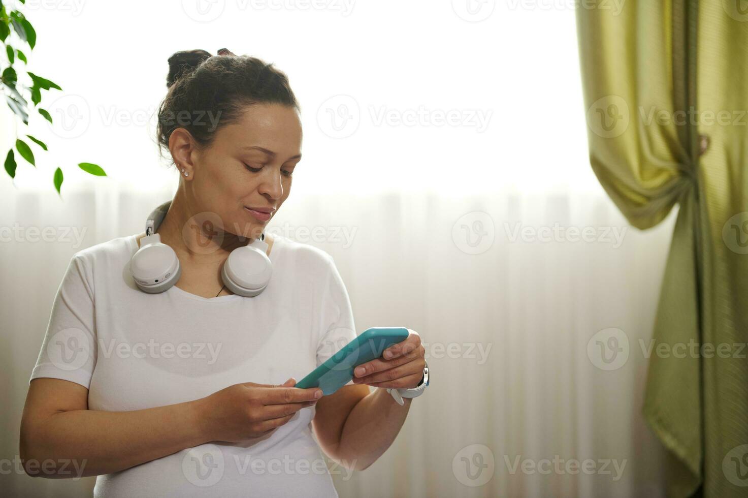 Premium Photo  Happy pregnant woman holding headphones on her belly at  home pregnancy people technology concept