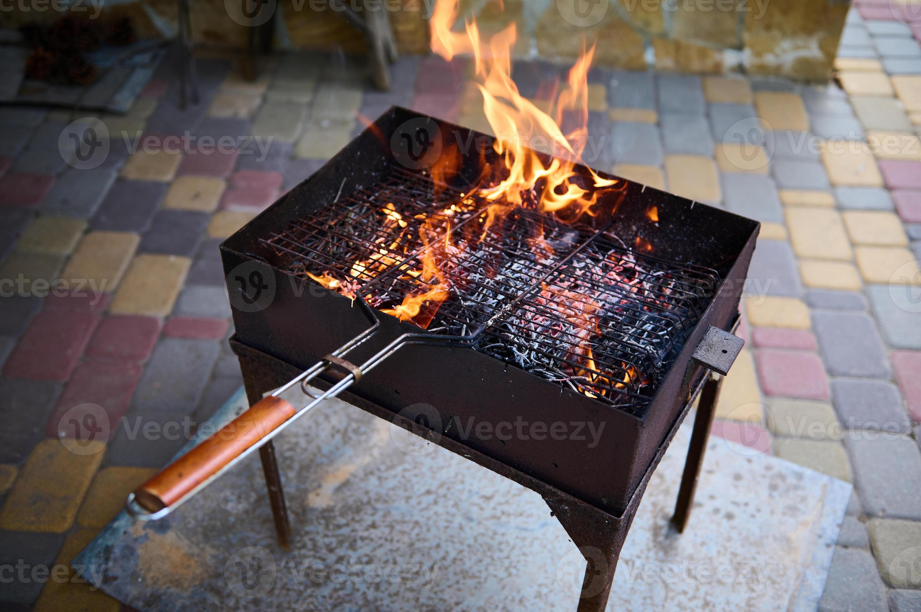 Empty flaming charcoal grill with open fire, ready for product