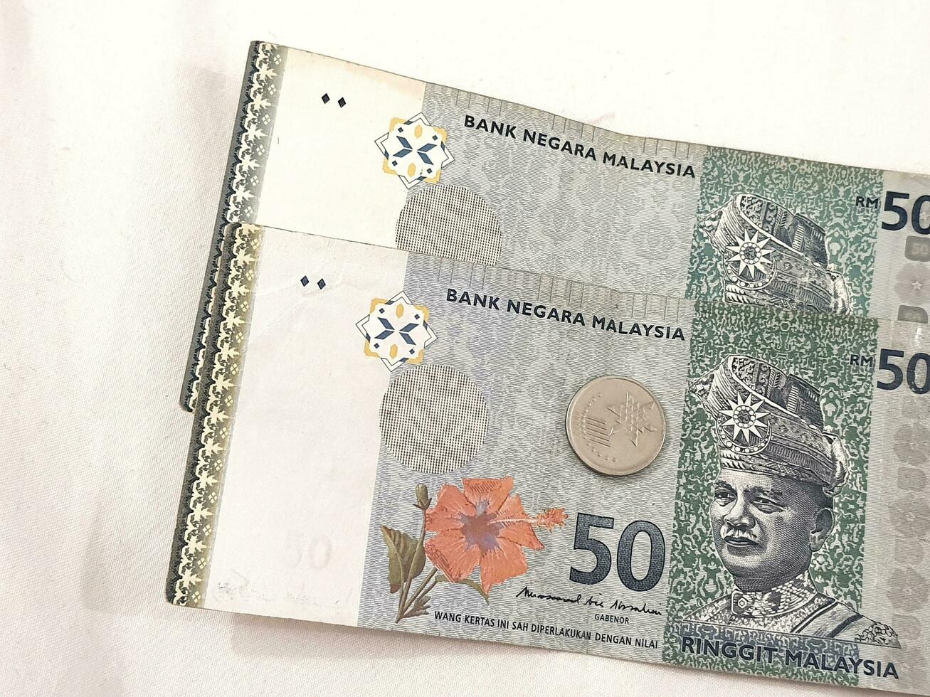 Two 50 ringgit notes, one coin of 10 cents ringgit. photo