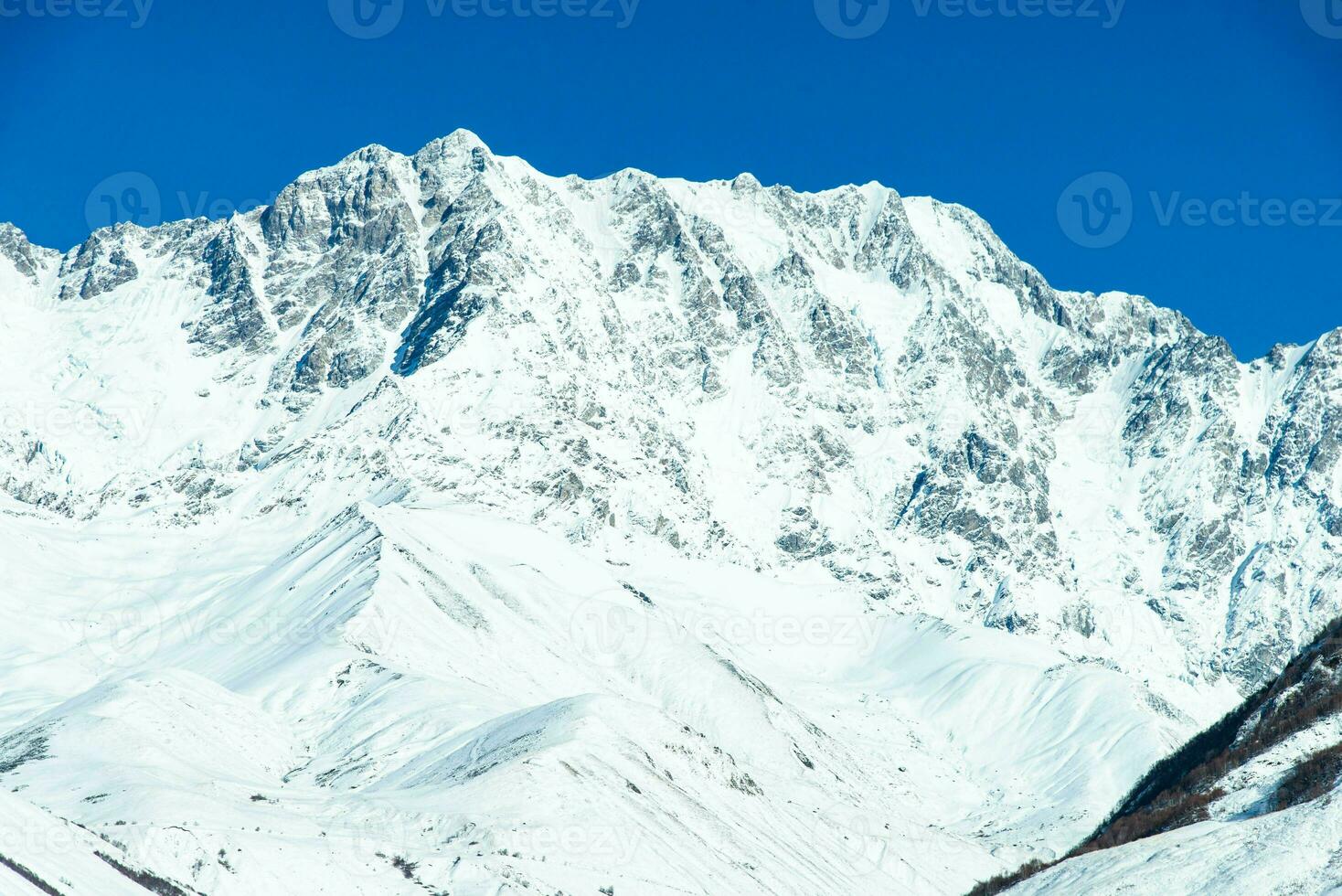 Beautiful sceneric view of Caucasus mountain. The way to mountain with pine forest covered with snow in winter season at Mestia Georgia photo