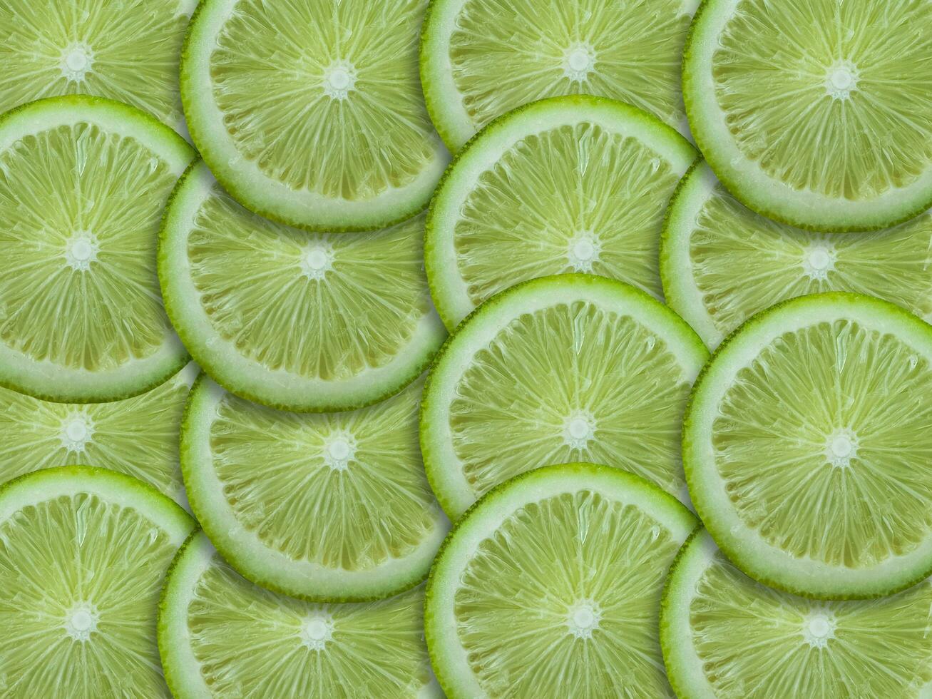 Slices of fresh green lemons top view background image photo