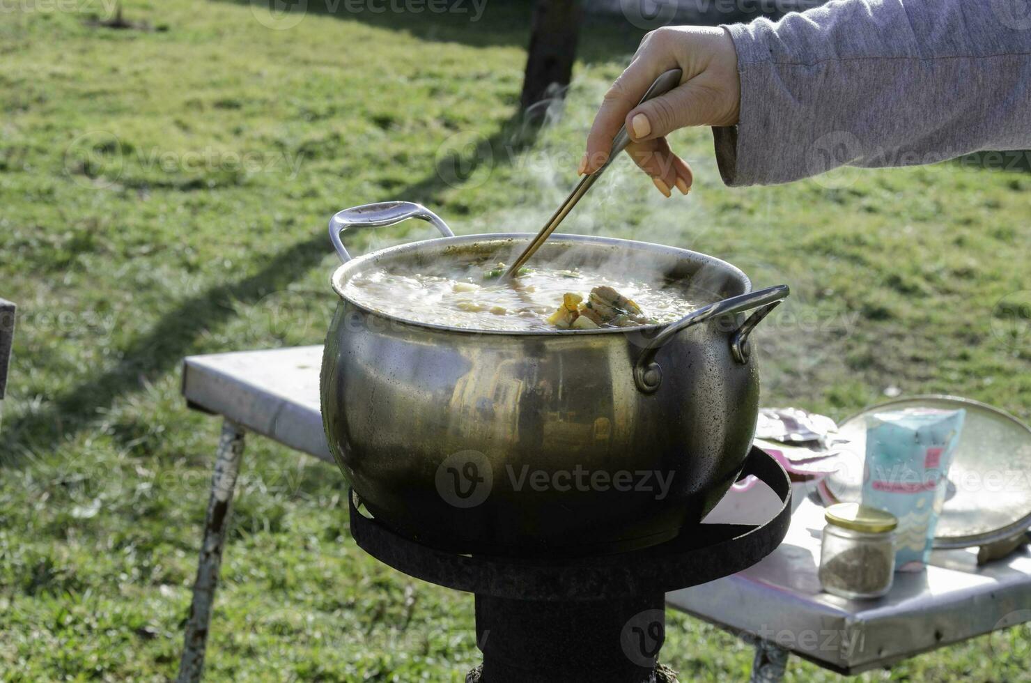 Cocinando en el yarda durante difícil veces. un cacerola en cuales sopa de remolacha es cocido en el estufa en el patio trasero. foto