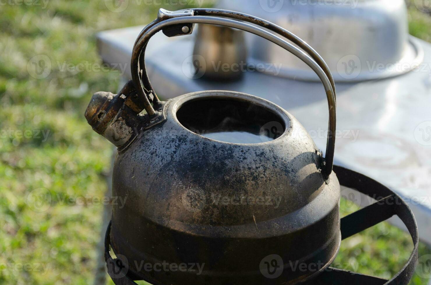 Kettle with water on the stove outside. Boiling water in difficult times. photo