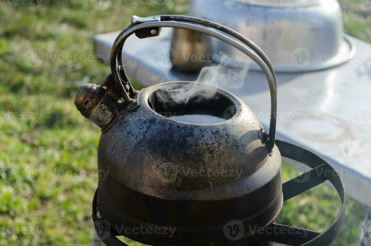 Kettle with water on the stove outside. Boiling water in difficult times. photo