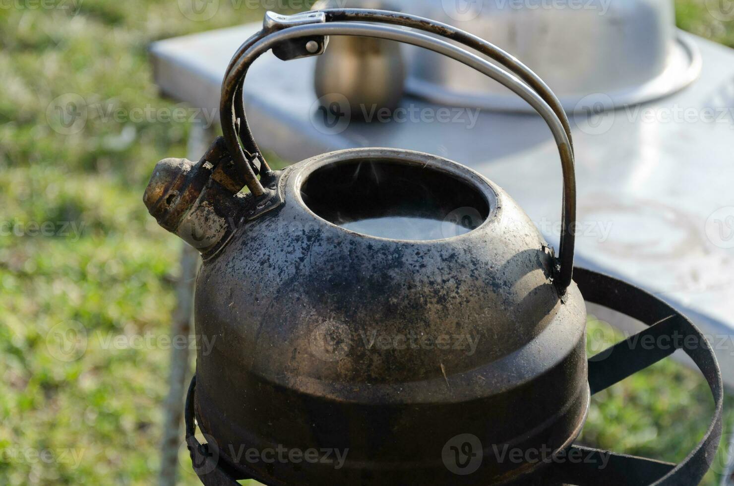 Kettle with water on the stove outside. Boiling water in difficult times. photo