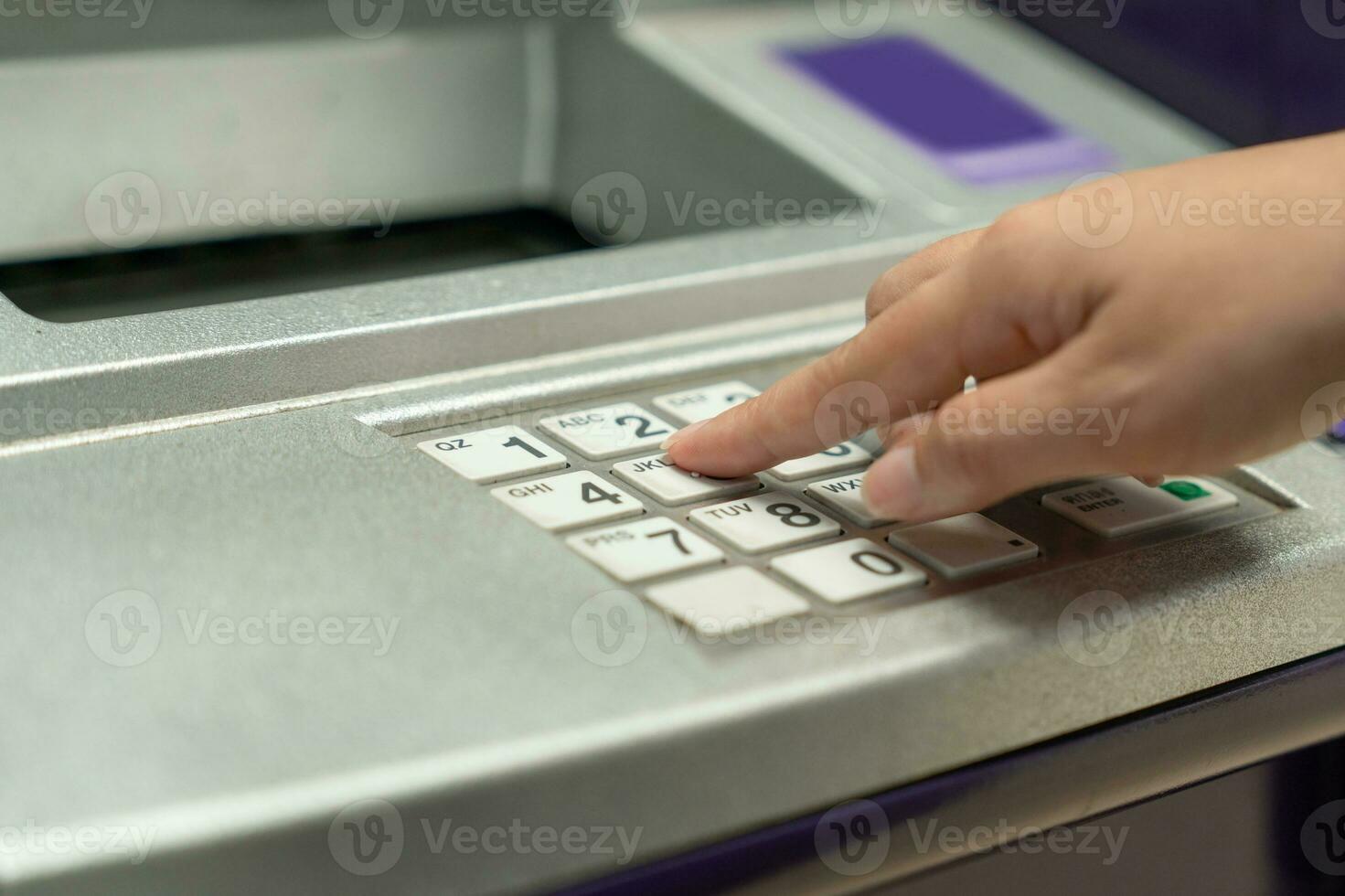 Finger pressing password number on ATM machine photo