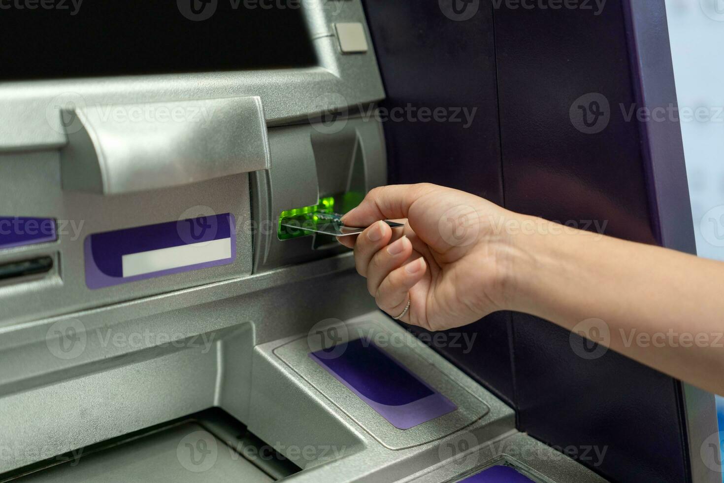 Hand about to insert card to ATM machine ready to withdraw or transfer money. photo
