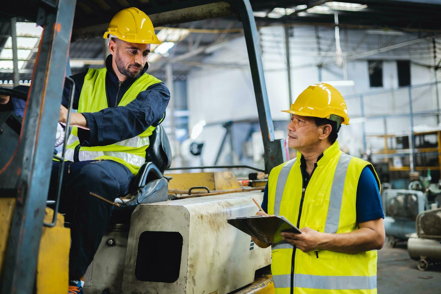 warehouse worker talking with forklift operator in factory photo