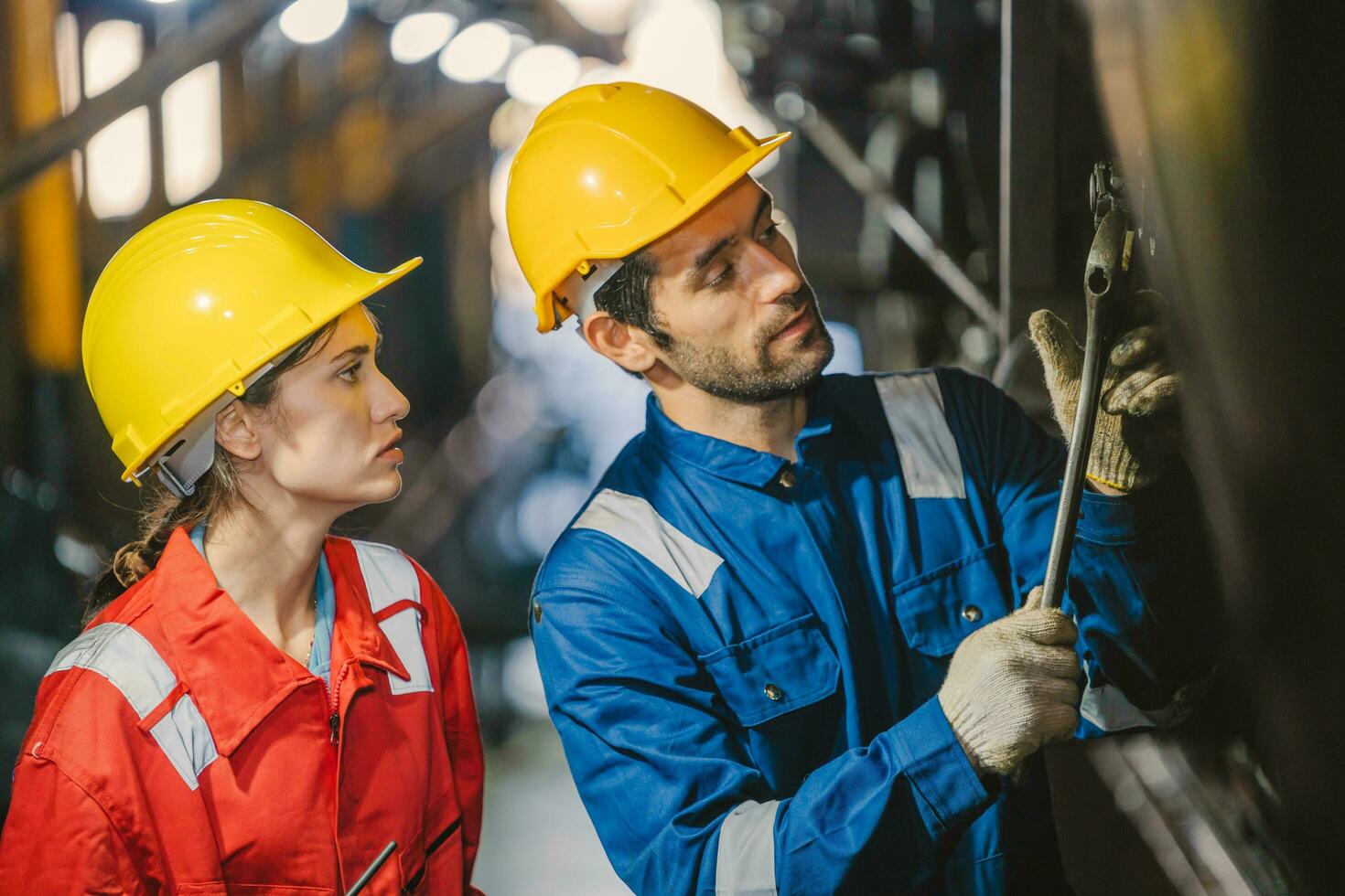 Female engineer and worker checking equipment in factory for repair photo