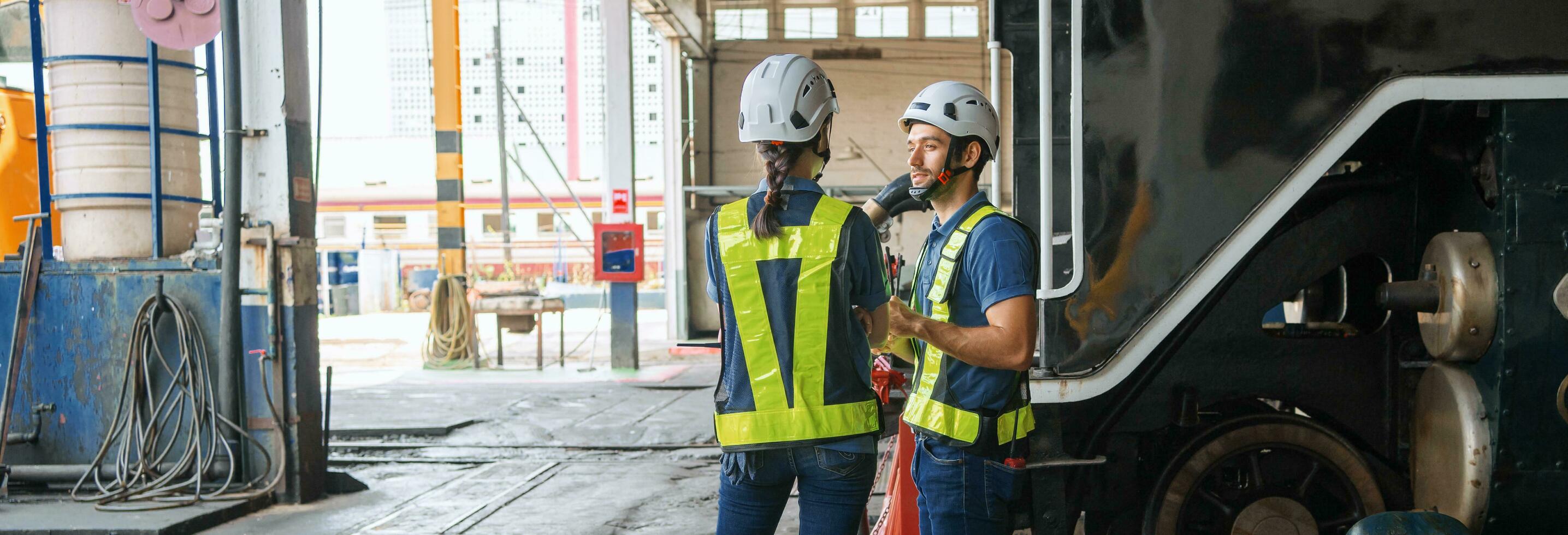 Engineer with worker talking together at factory photo