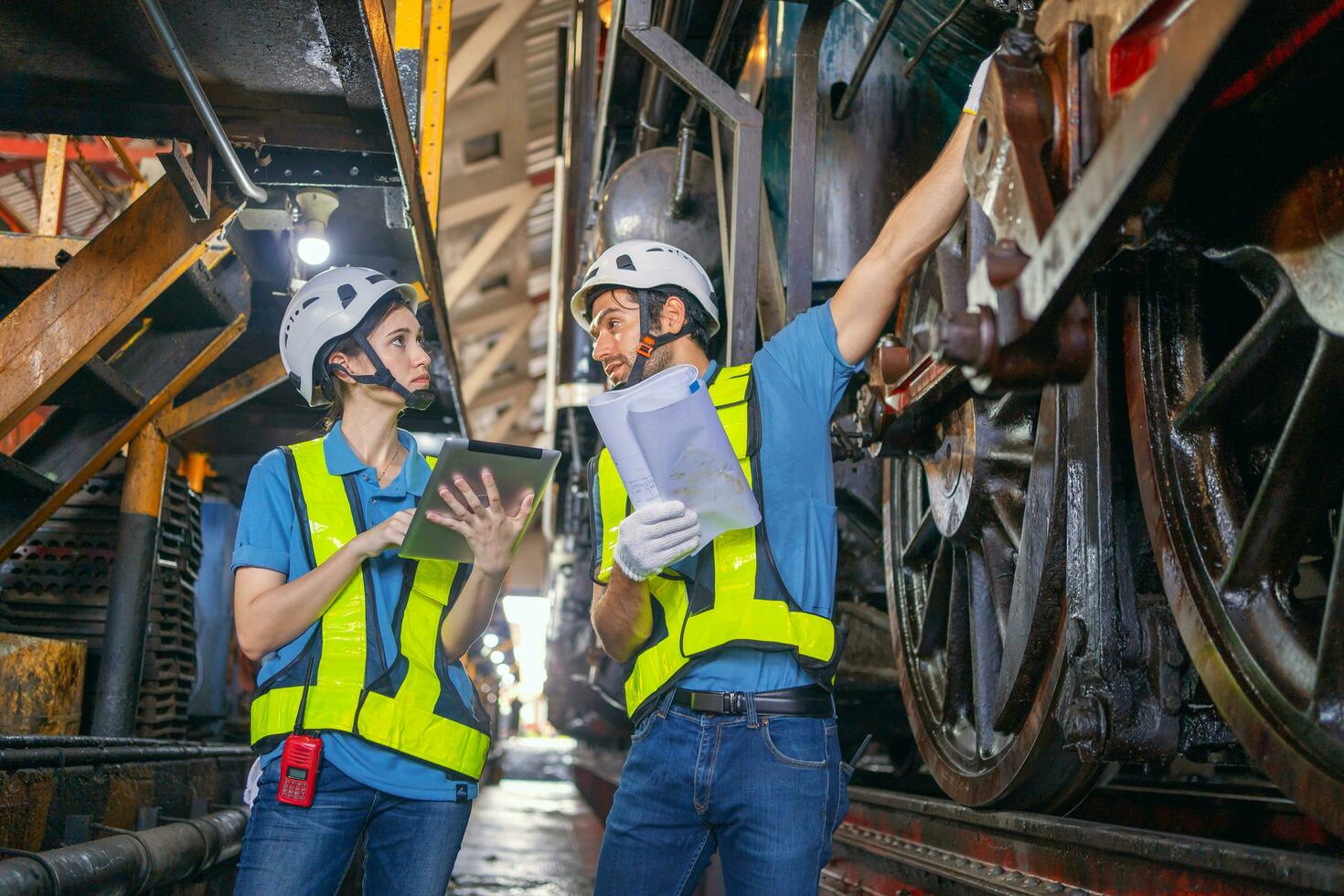 Female engineer and worker checking equipment in factory for repair photo