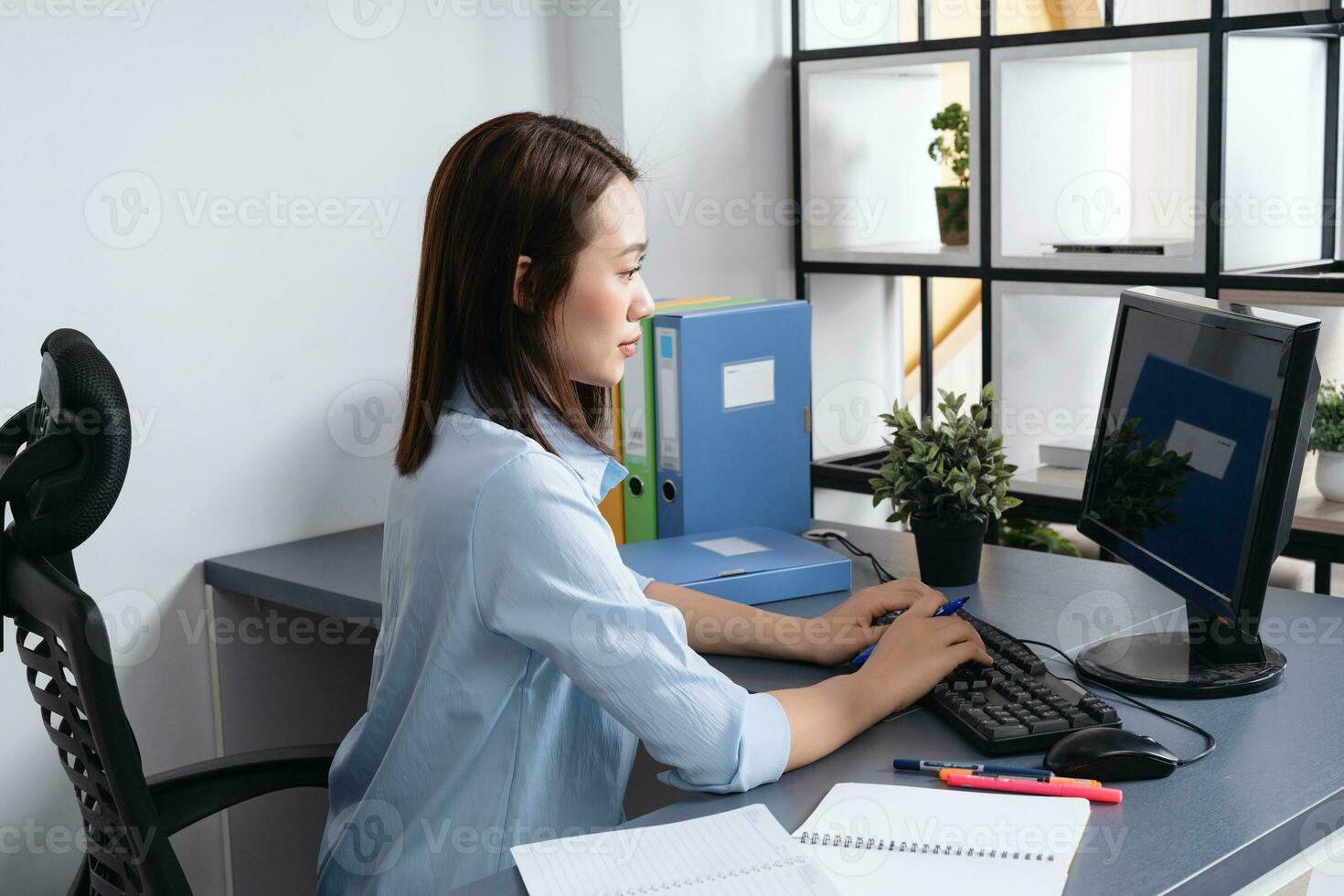 Photo of young Asian businesswoman working at office