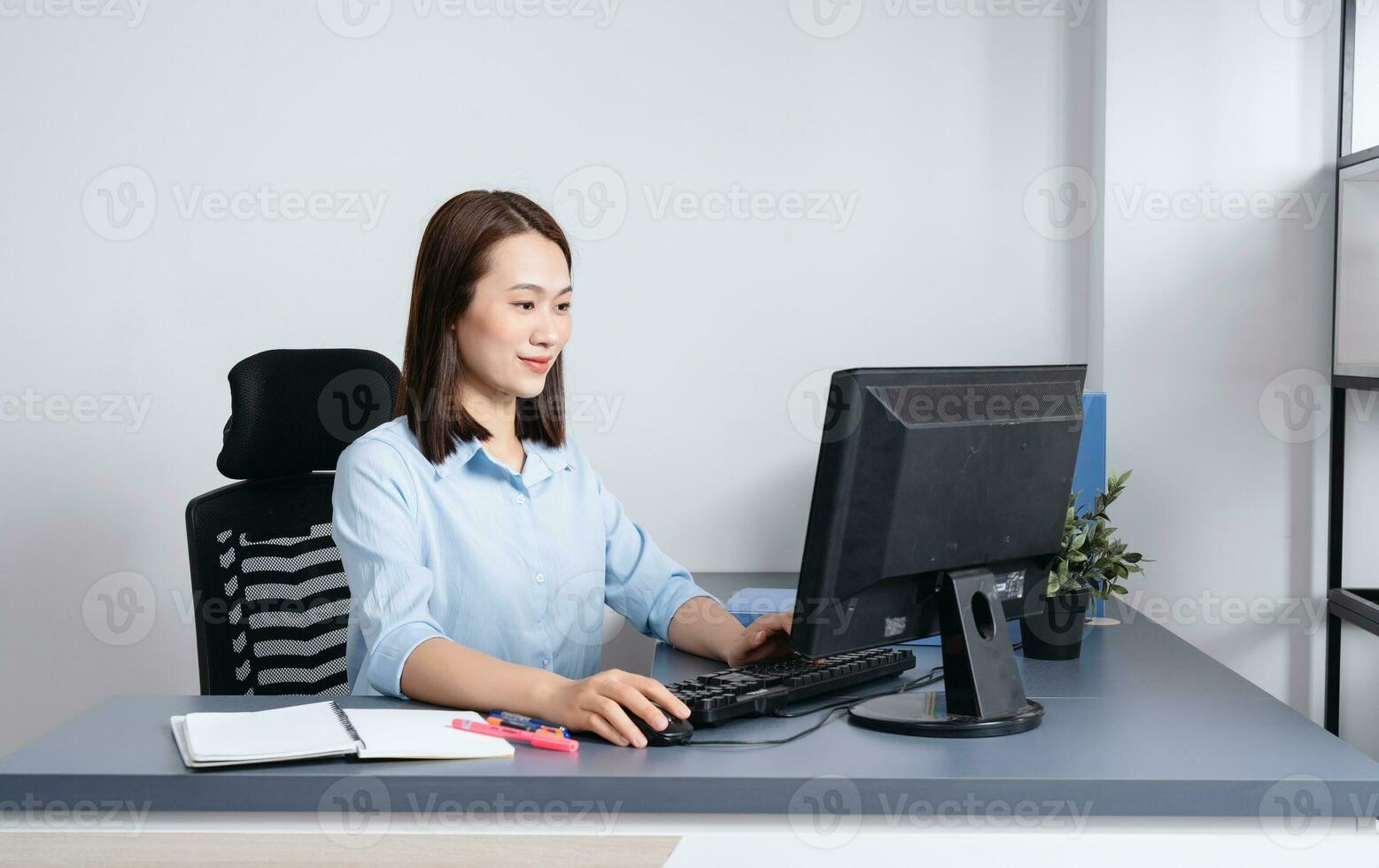 Photo of young Asian businesswoman working at office