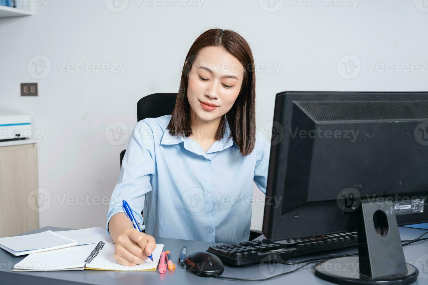 Photo of young Asian businesswoman working at office