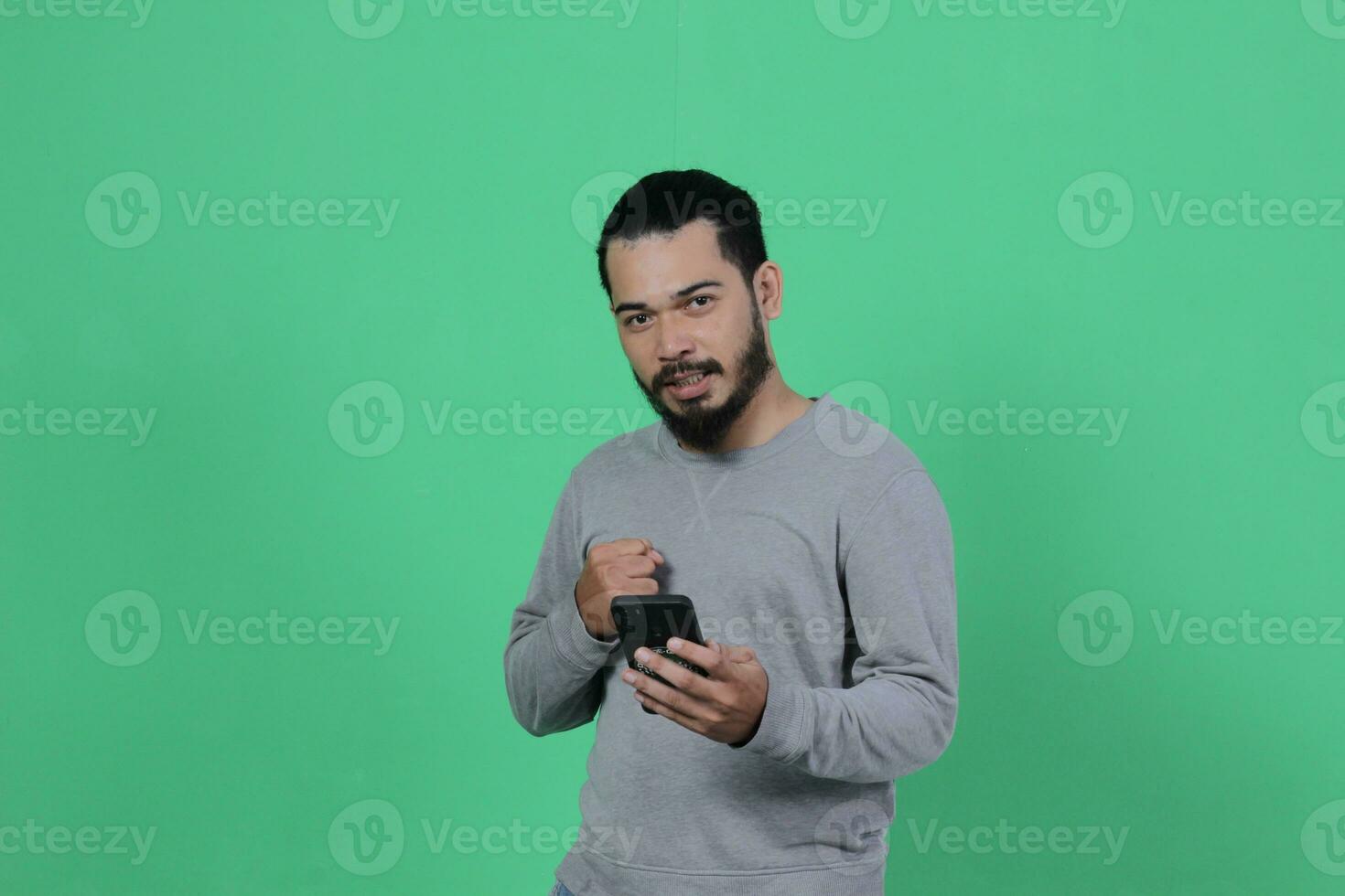 asiático hombre expresión mientras utilizando teléfono inteligente foto