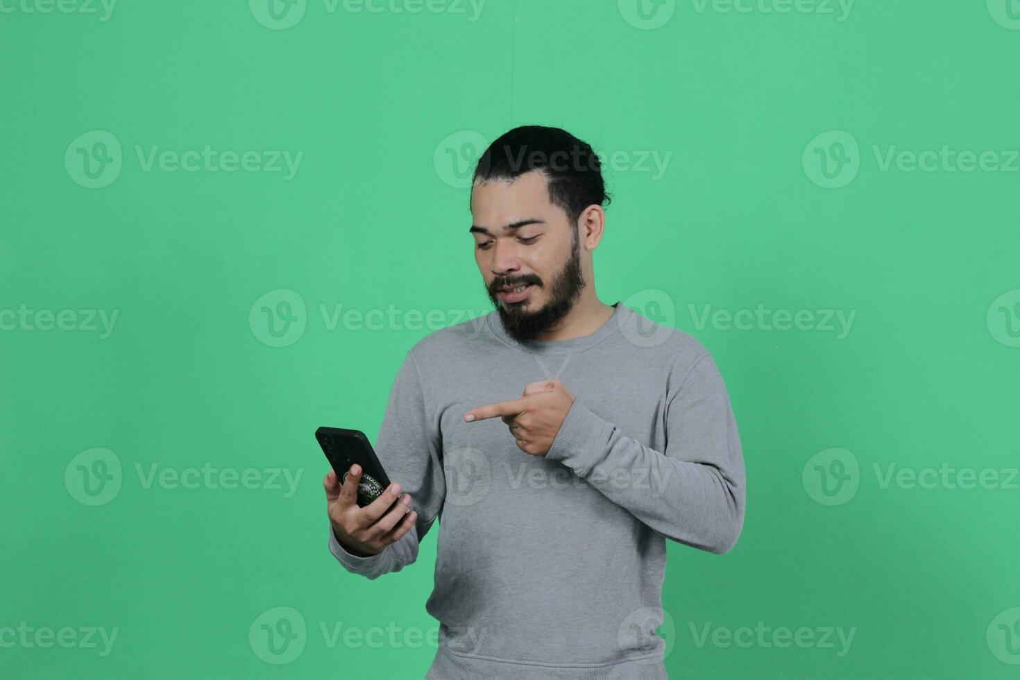 asiático hombre expresión mientras utilizando teléfono inteligente foto