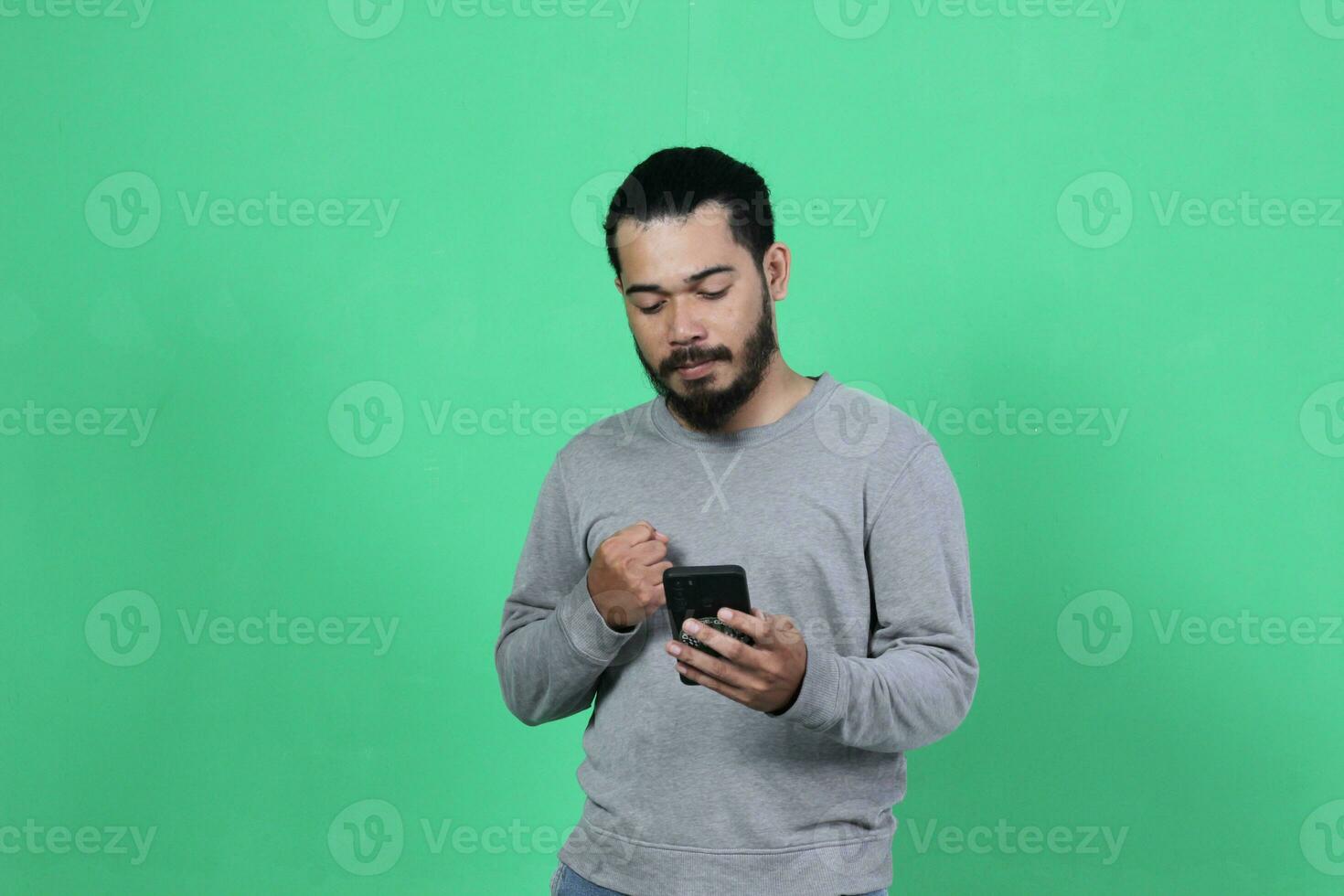 asian man expression while using smartphone photo