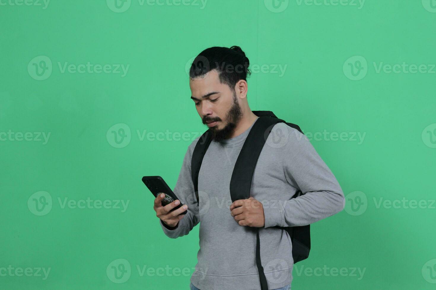 bearded asian student expression using smartphone photo