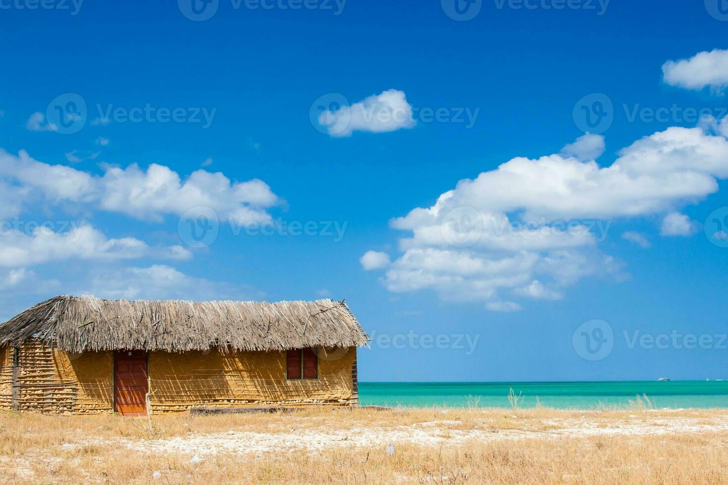 Colorful adobe house next to the sea under blue sky in La Guajira in Colombia photo