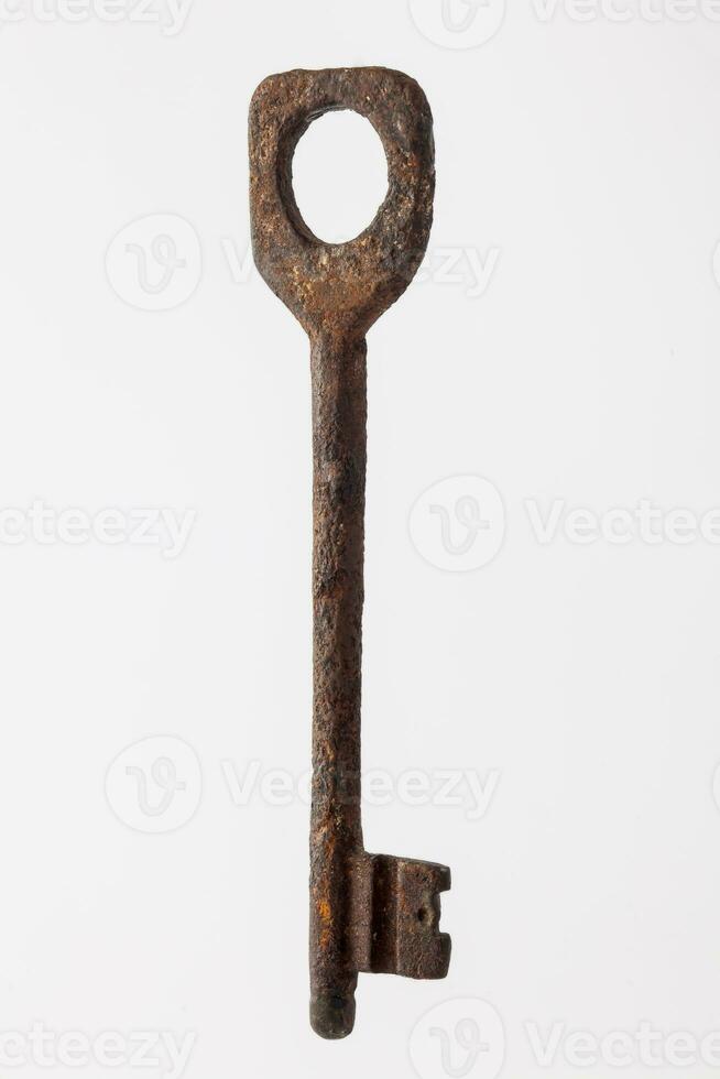 Antique rusty key isolated on white background photo