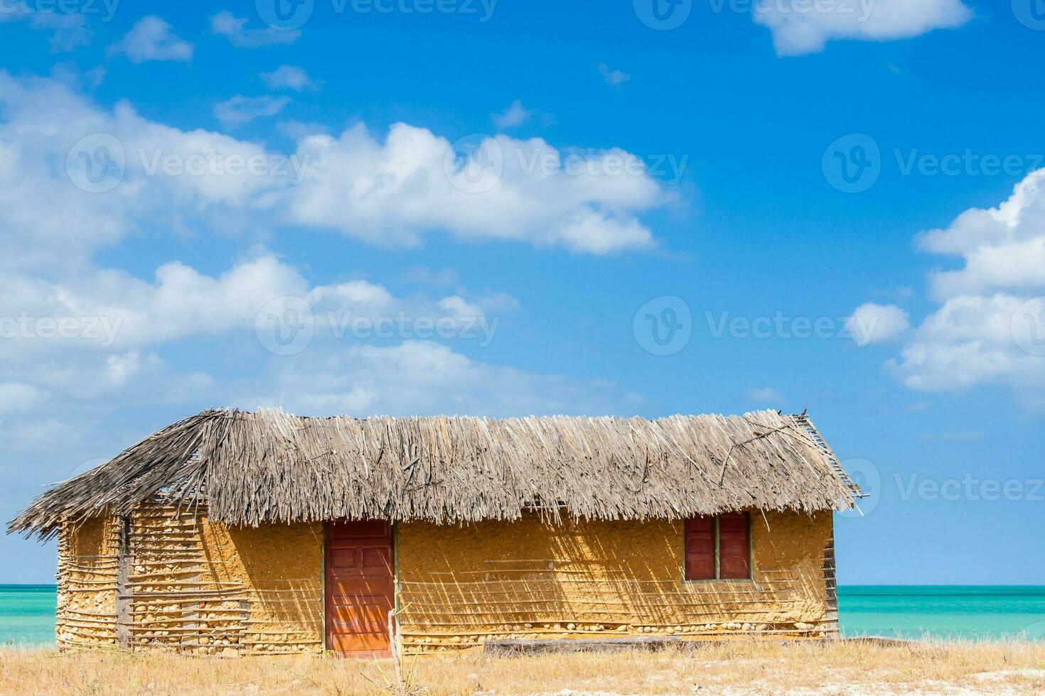 Colorful adobe house next to the sea under blue sky in La Guajira in Colombia photo