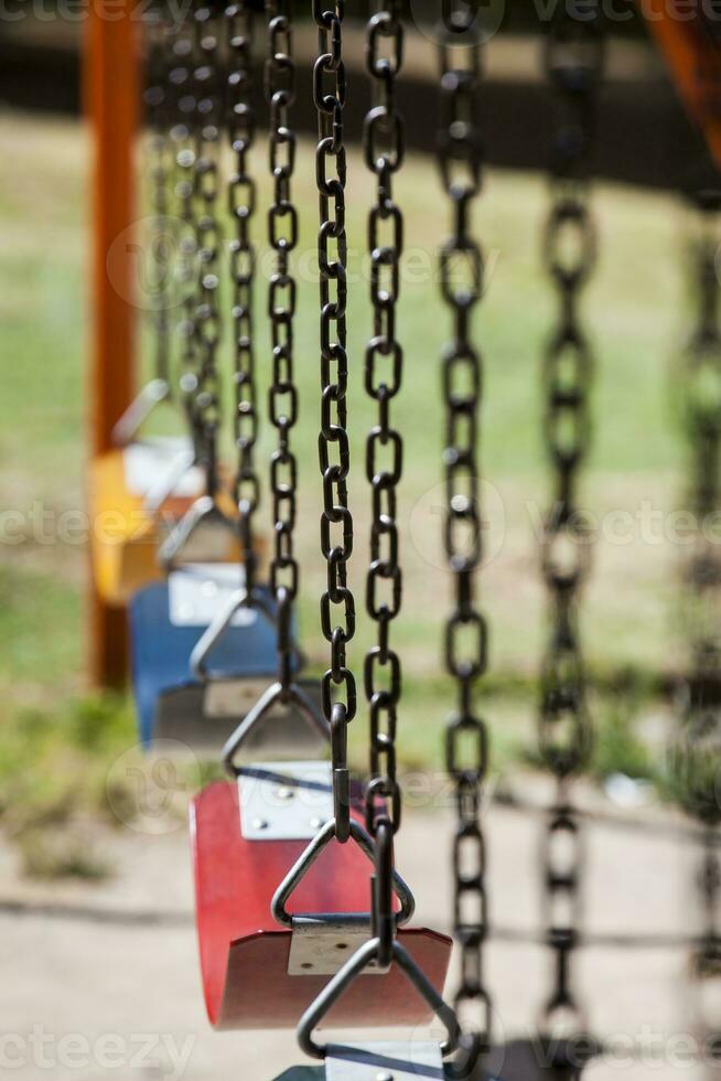 Empty colorful swings at the park photo