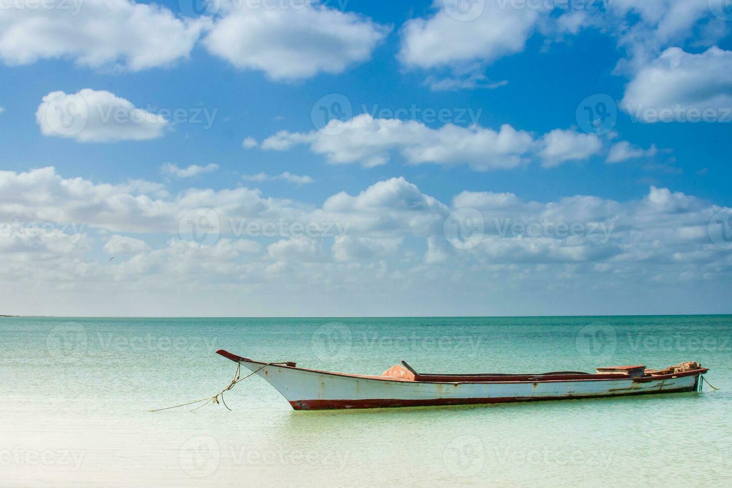 Canoe floating on calm water under beautiful blue sky in La Guajira in Colombia photo