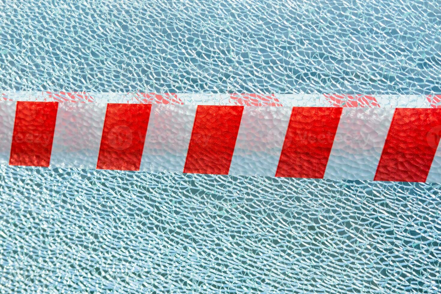 broken glass background with red and white ribbon. Danger sign and stop photo
