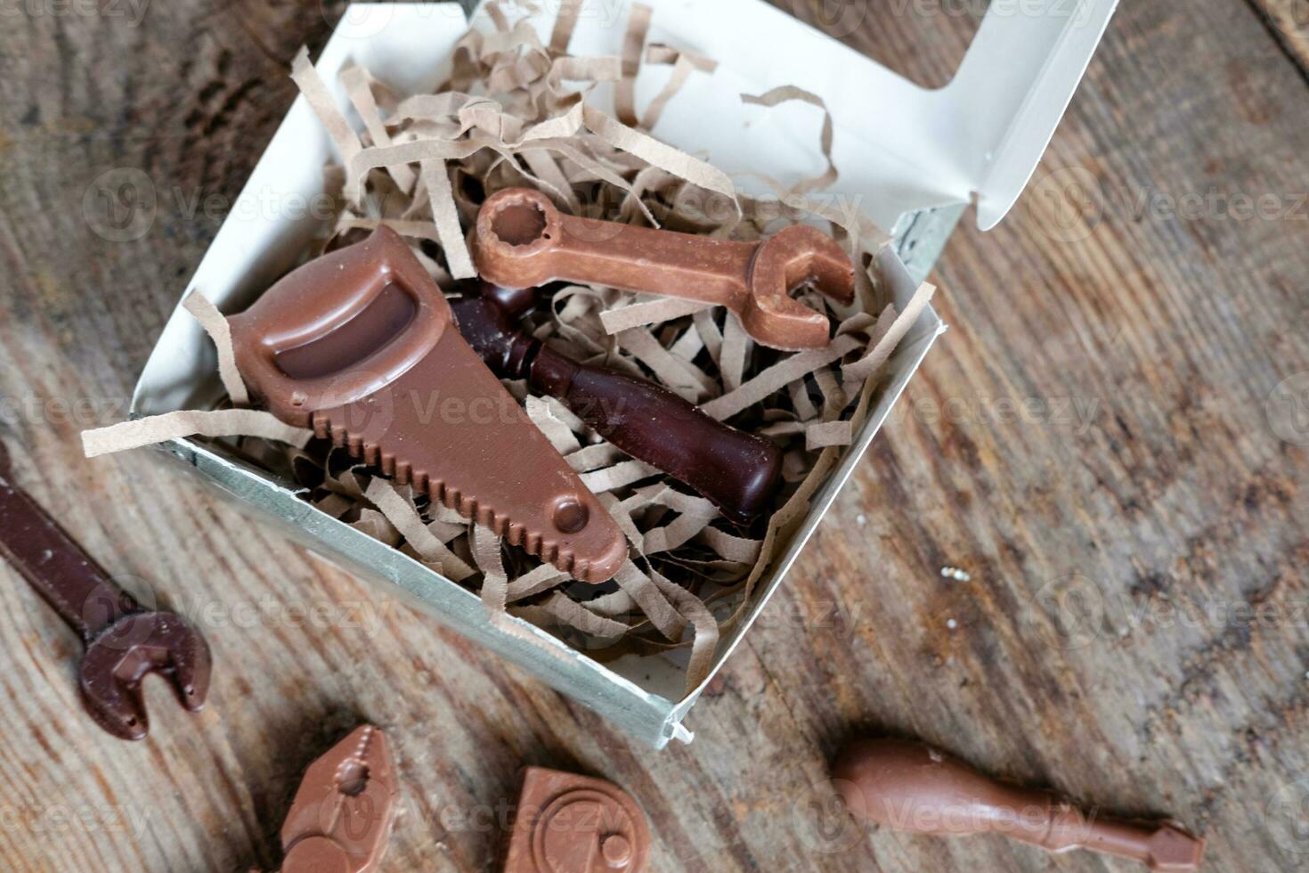 https://static.vecteezy.com/system/resources/previews/024/721/704/non_2x/chocolate-shaped-tools-in-a-box-on-a-wooden-background-sweet-chocolate-gift-for-a-man-photo.jpg