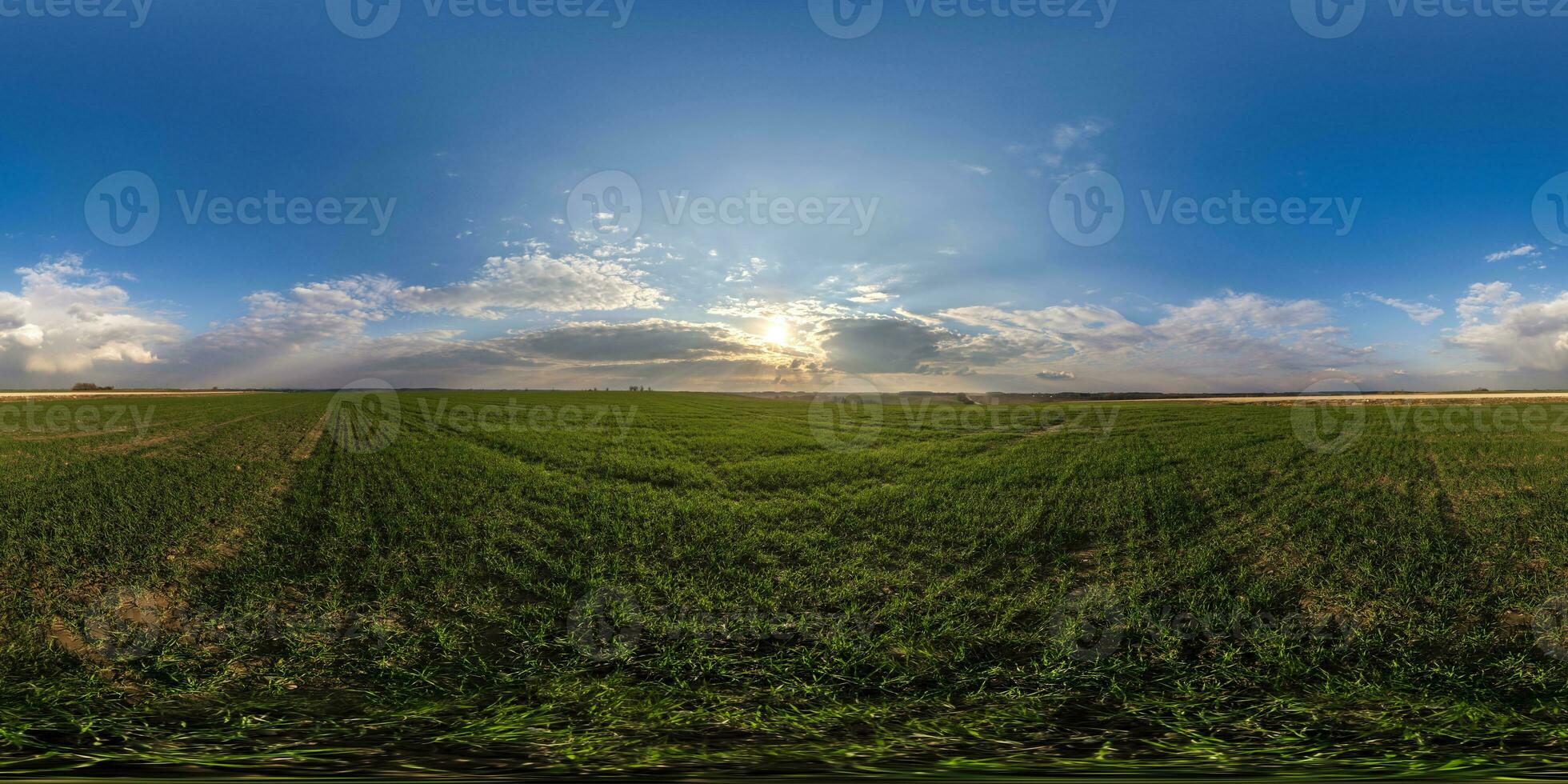 360 hdri panorama view among fields with sunset sky in golden hour in countryside with tractor tires in equirectangular seamless spherical projection.  use like sky replacement for drone shots photo