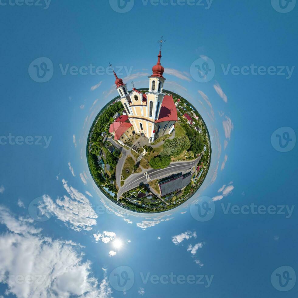 little planet transformation of spherical panorama 360 degrees overlooking church in center of globe in blue sky. Spherical abstract aerial view with curvature of space. photo