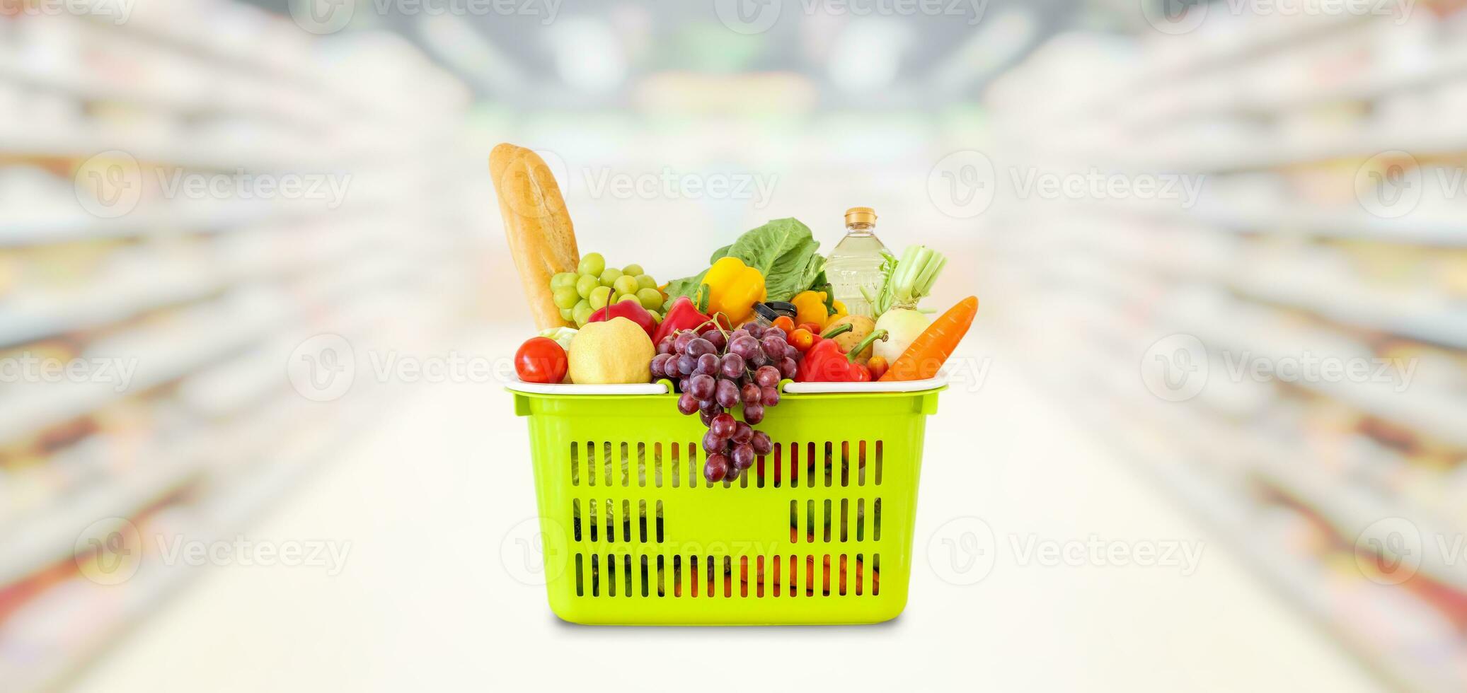 Shopping basket with fruits and vegetables in supermarket grocery store blurred background photo