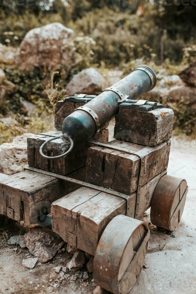 An old fashioned cannon with a wooden carriage and a cast iron barrel for firing cannonballs photo