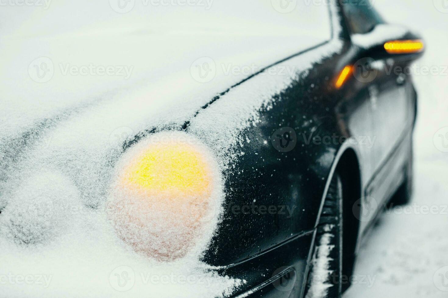 Car under snow with hazard warning lights on - emergency stop in frosty weather in difficult weather conditions photo