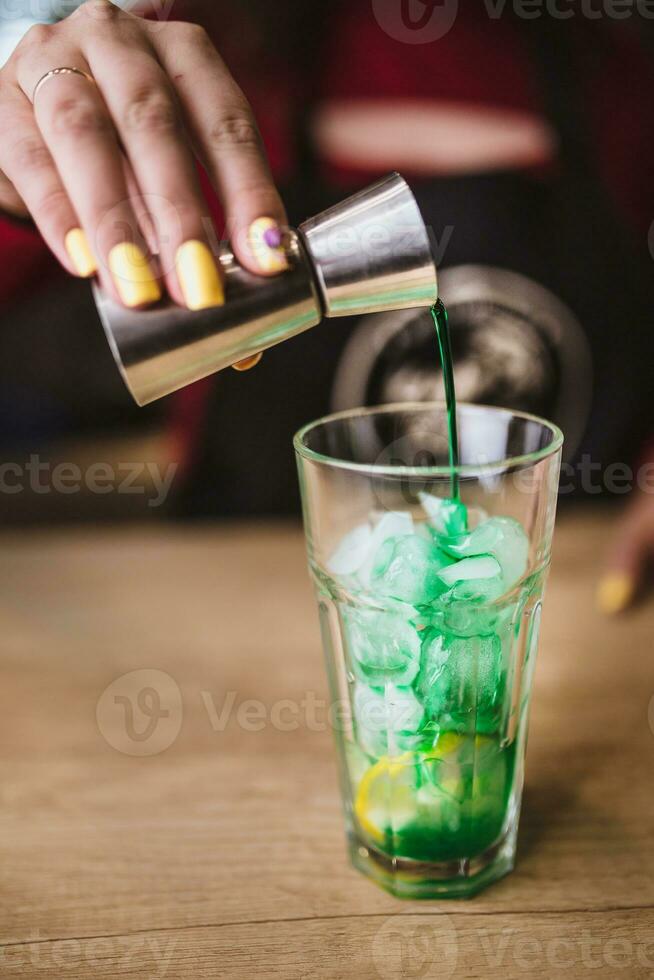 haciendo un verde cóctel en un vaso vaso a un bar - limón y plátano jarabe foto